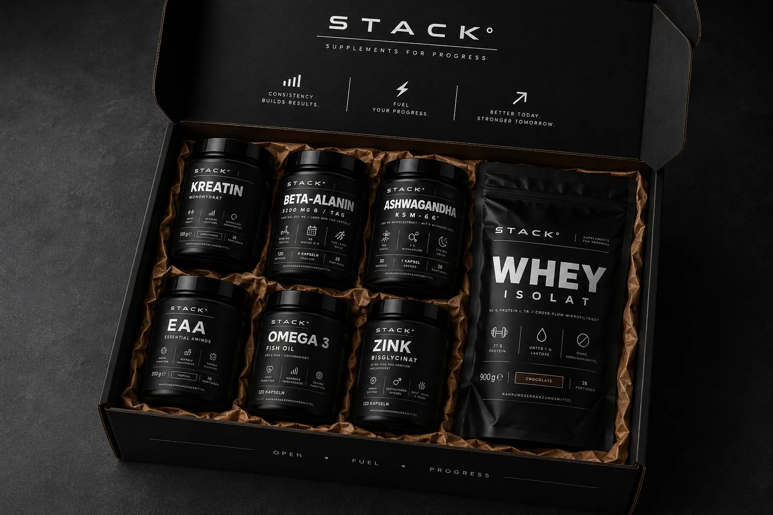 Geöffnete schwarze STACK°-Box: Dosen und Whey-Beutel in Kraftpapier